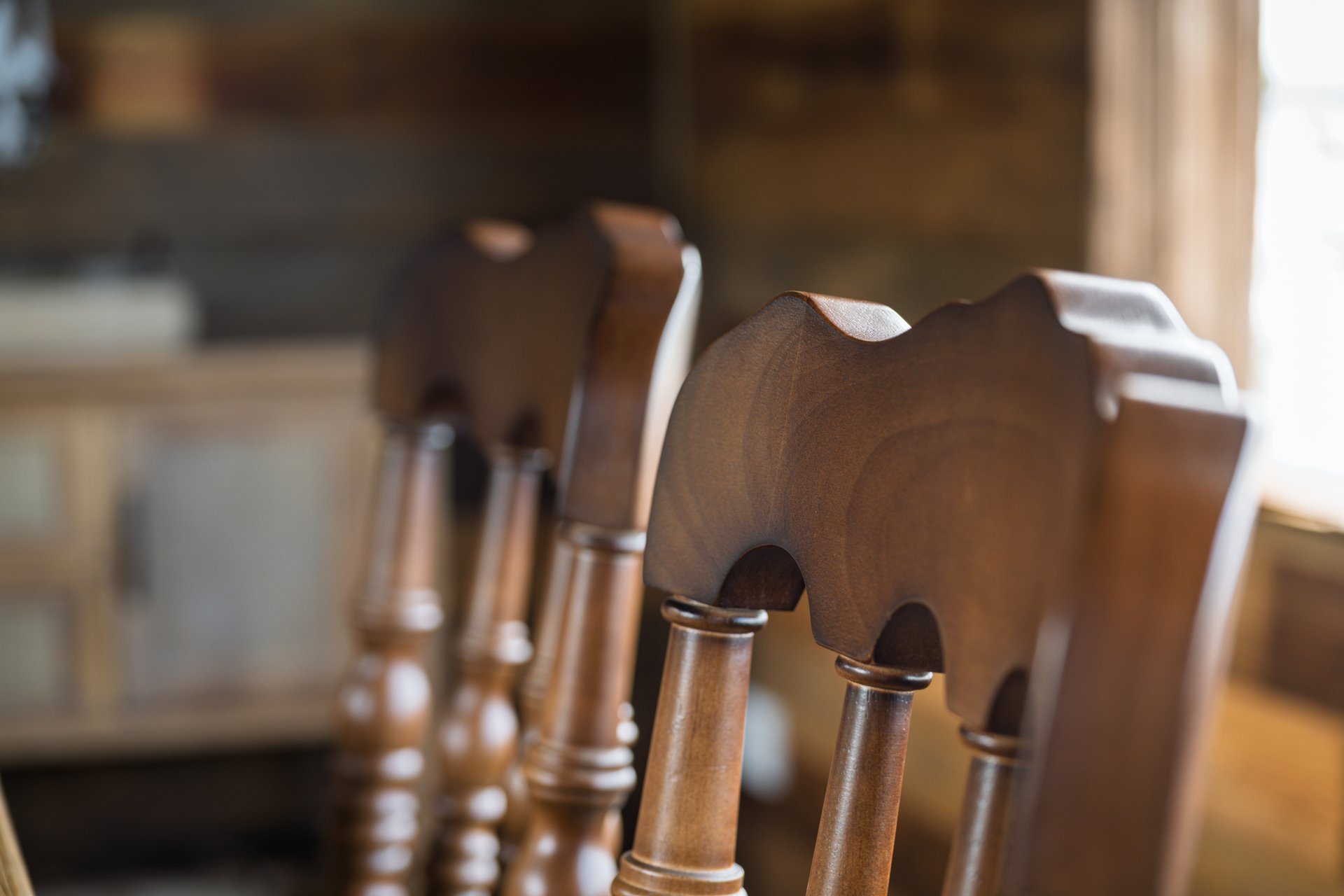 Vintage wooden chairs with intricate carved backrests in a rustic interior setting