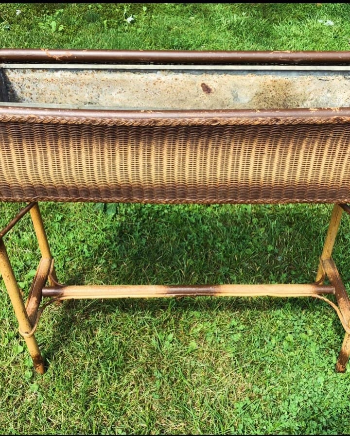 Vintage bench with woven rattan backrest on grass