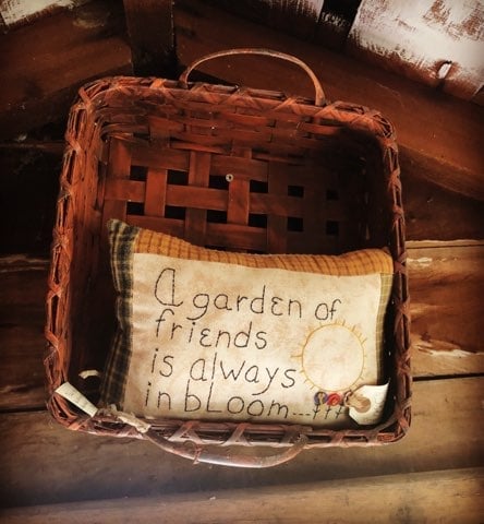 Woven basket with embroidered garden pillow