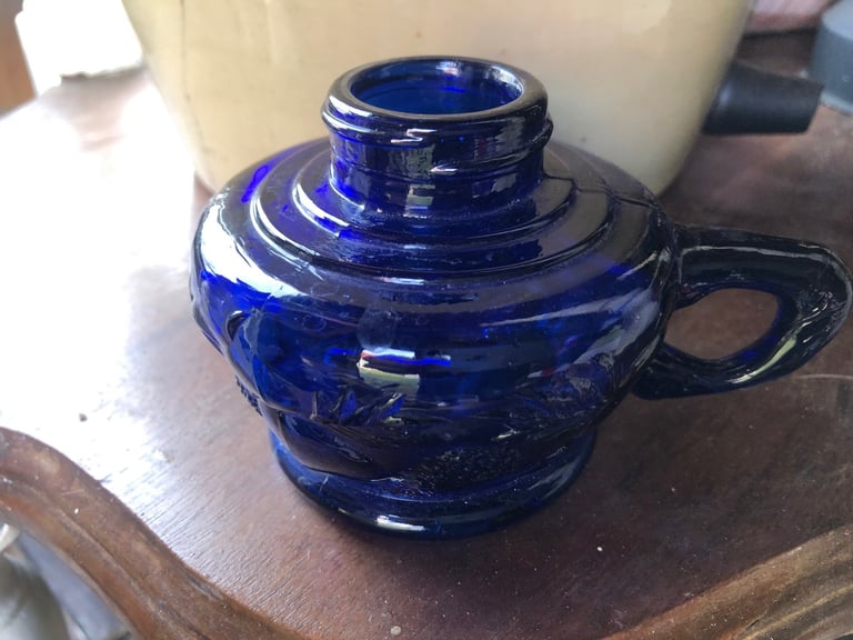 Cobalt blue glass teapot with lid and handle sitting on a wooden surface