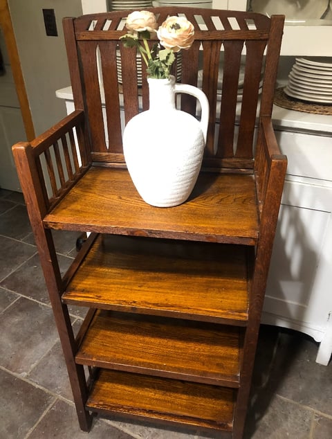 Wooden chair with shelves displaying white vase with cream roses on top shelf in kitchen
