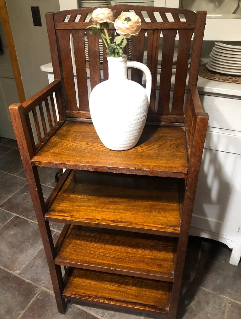 Wooden chair with shelves displaying white vase with cream roses on top shelf in kitchen
